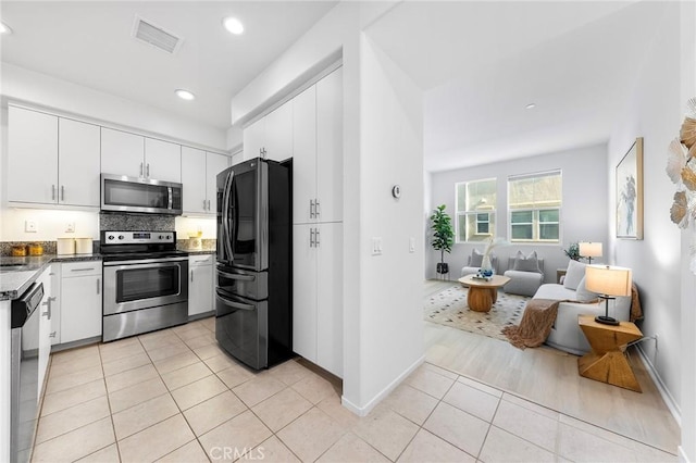 kitchen featuring white cabinets, appliances with stainless steel finishes, and light tile patterned flooring