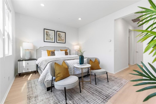 bedroom with multiple windows and light hardwood / wood-style floors