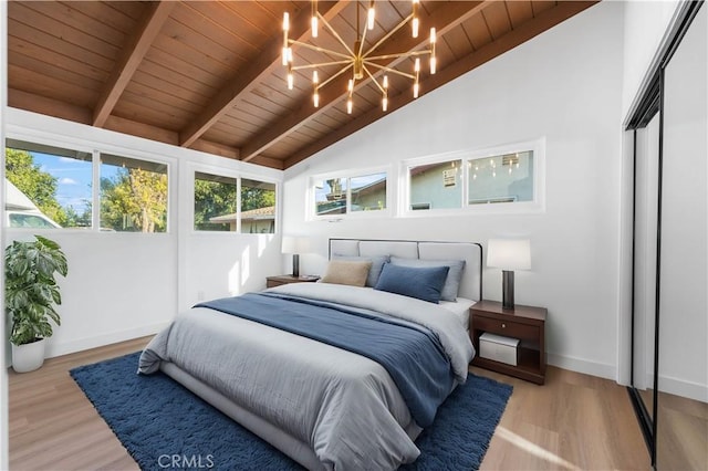 bedroom featuring light hardwood / wood-style floors, vaulted ceiling with beams, an inviting chandelier, wood ceiling, and a closet