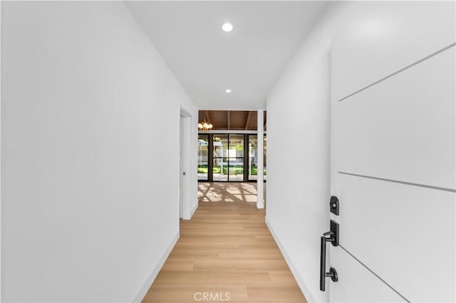 hall featuring an inviting chandelier and light hardwood / wood-style floors