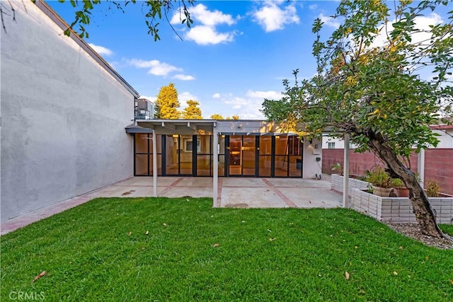 rear view of property with a yard and a patio