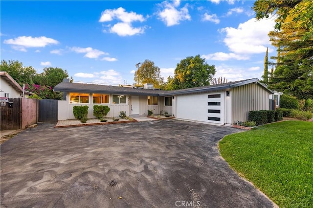 single story home featuring a front lawn and a garage