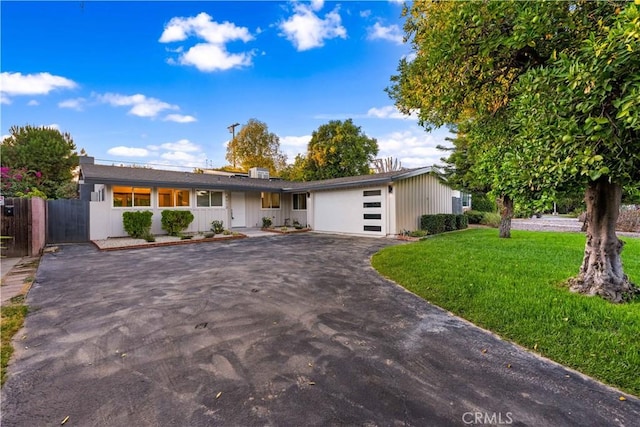 single story home with a garage and a front lawn