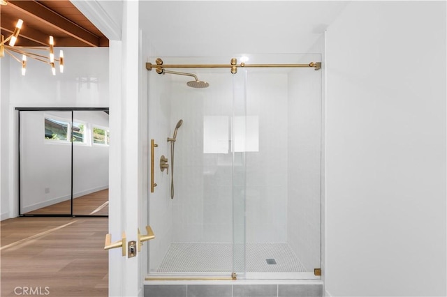 bathroom with a chandelier, wood-type flooring, and walk in shower