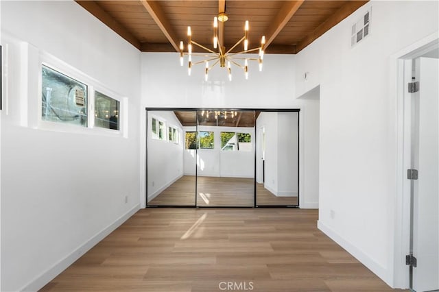 doorway to outside featuring wooden ceiling, hardwood / wood-style floors, beam ceiling, and a notable chandelier