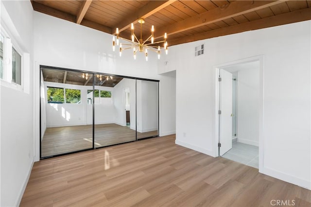 unfurnished bedroom featuring lofted ceiling with beams, a notable chandelier, wood ceiling, and light hardwood / wood-style flooring