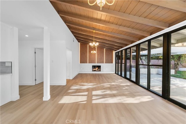 unfurnished living room featuring beam ceiling, wood ceiling, a chandelier, and light hardwood / wood-style floors