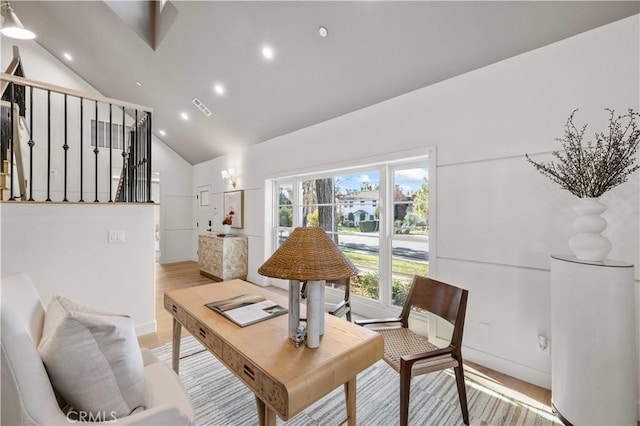 living room featuring lofted ceiling and light hardwood / wood-style flooring