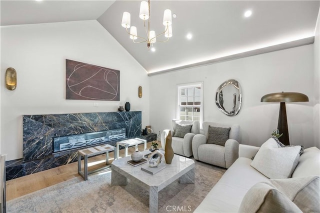 living room featuring light hardwood / wood-style floors, lofted ceiling, and an inviting chandelier