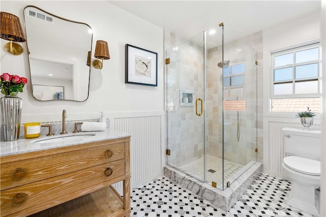 bathroom with vanity, a shower with shower door, tile patterned floors, and toilet