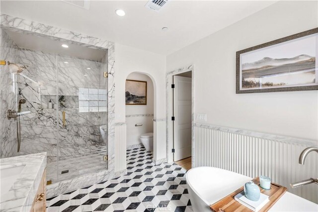 full bathroom featuring toilet, vanity, and shower with separate bathtub