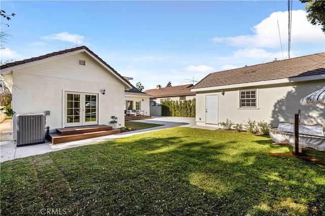 back of house featuring a yard, central air condition unit, and french doors