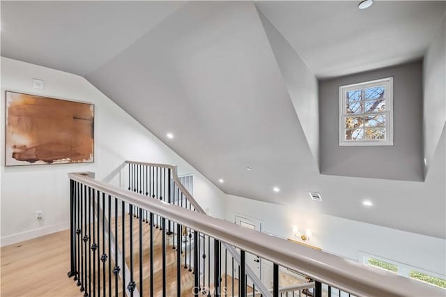 corridor with lofted ceiling and light hardwood / wood-style floors