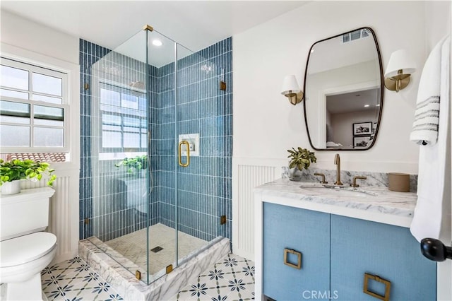 bathroom with vanity, tile patterned flooring, a shower with door, and toilet