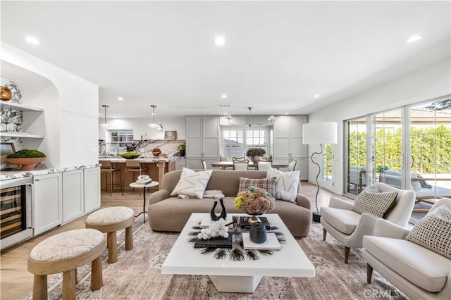 living room with wine cooler and light hardwood / wood-style floors