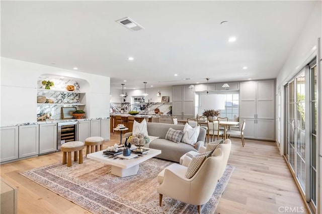 living room with light hardwood / wood-style floors and wine cooler