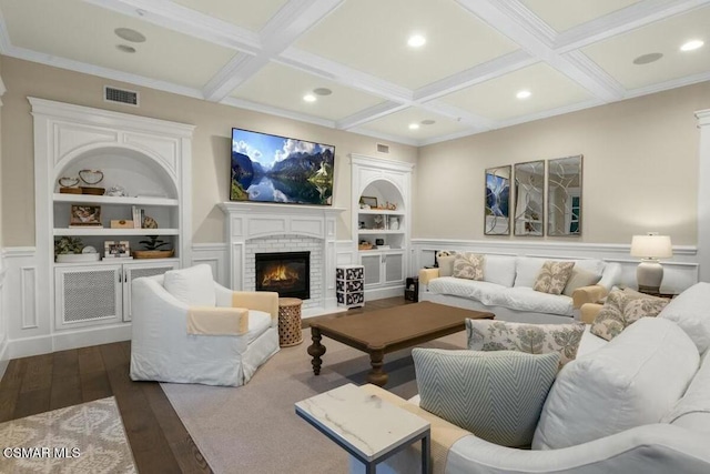 living room featuring built in shelves, coffered ceiling, beamed ceiling, and a fireplace