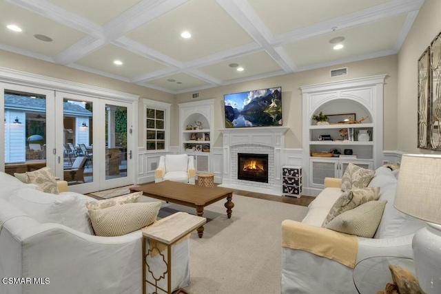 living room with a fireplace, french doors, built in features, and hardwood / wood-style flooring