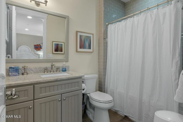 bathroom with toilet, vanity, and a shower with shower curtain