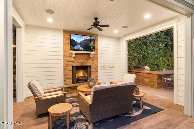 view of patio with ceiling fan and an outdoor stone fireplace