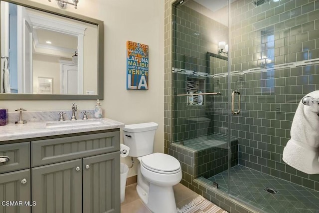 bathroom with an enclosed shower, vanity, tile patterned flooring, and toilet