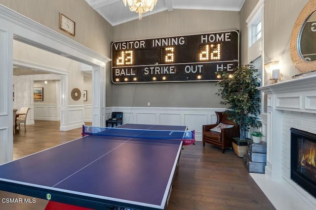 recreation room featuring lofted ceiling with beams, a brick fireplace, and hardwood / wood-style flooring