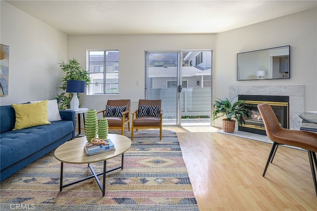 living room with a tiled fireplace and hardwood / wood-style floors