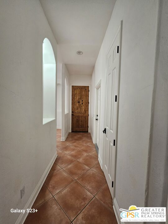 corridor featuring dark tile patterned flooring