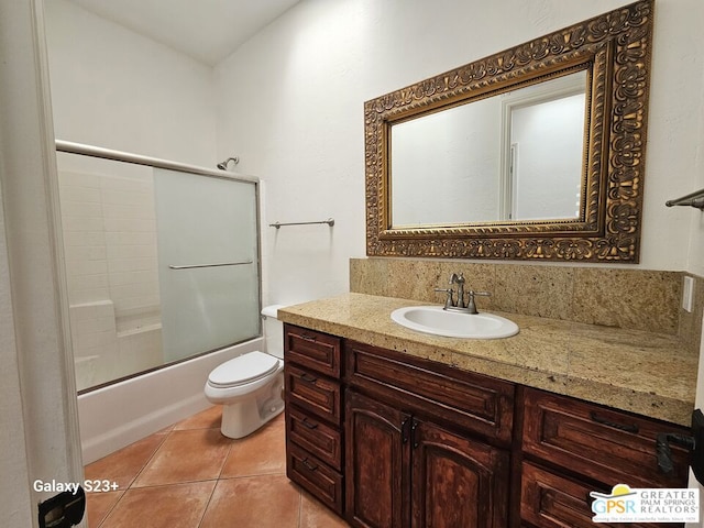 full bathroom with tile patterned floors, shower / bath combination with glass door, vanity, and toilet