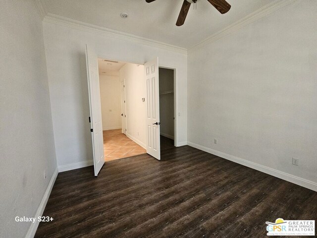 unfurnished bedroom with dark wood-type flooring, ceiling fan, ornamental molding, and a closet