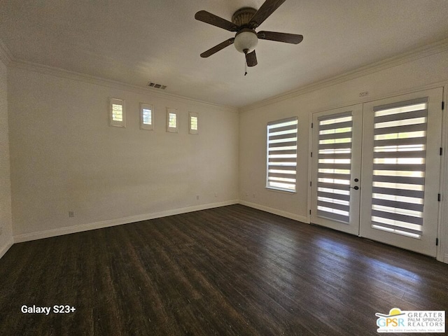 empty room with ceiling fan, french doors, dark hardwood / wood-style floors, and crown molding