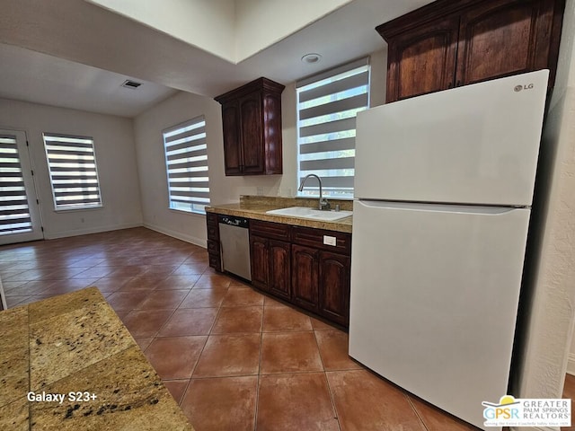 kitchen featuring white fridge, dishwasher, dark brown cabinets, and sink