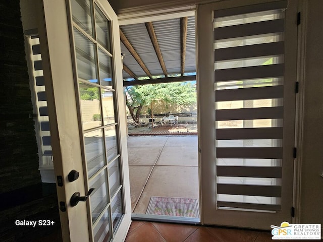 doorway to outside with tile patterned flooring