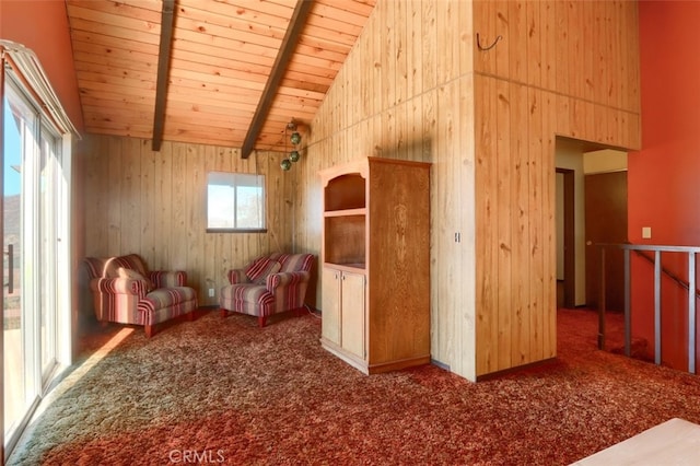 interior space featuring carpet floors, beamed ceiling, wood walls, high vaulted ceiling, and wooden ceiling