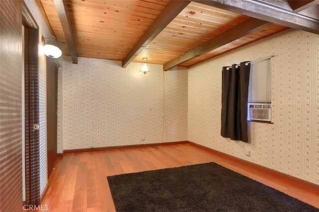 unfurnished room featuring wooden ceiling, cooling unit, beamed ceiling, and hardwood / wood-style flooring