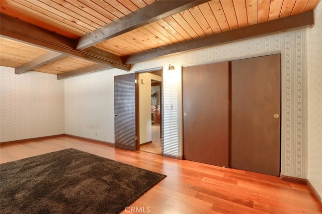 additional living space with wooden ceiling, wood-type flooring, and beam ceiling