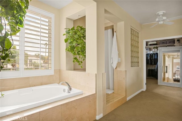 bathroom with plus walk in shower, ceiling fan, and a healthy amount of sunlight