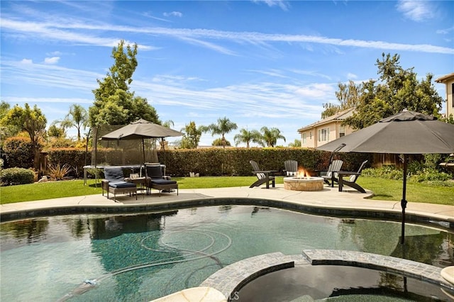 view of swimming pool featuring an in ground hot tub, a yard, a fire pit, and a patio