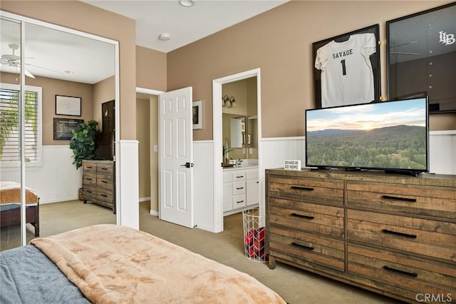 bedroom with light colored carpet and connected bathroom