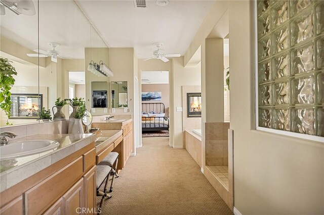 bathroom with ceiling fan, independent shower and bath, and vanity