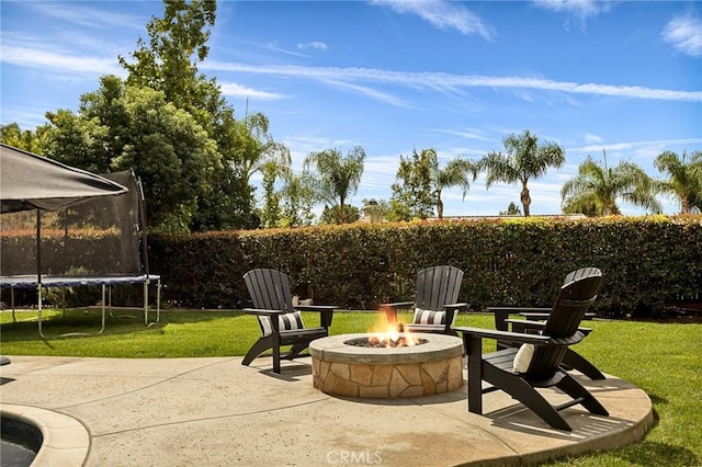 view of patio / terrace featuring a trampoline and a fire pit