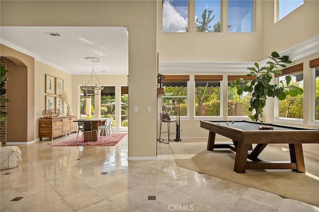 playroom featuring an inviting chandelier, plenty of natural light, pool table, and ornamental molding