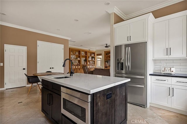 kitchen featuring white cabinetry, appliances with stainless steel finishes, a center island with sink, and sink