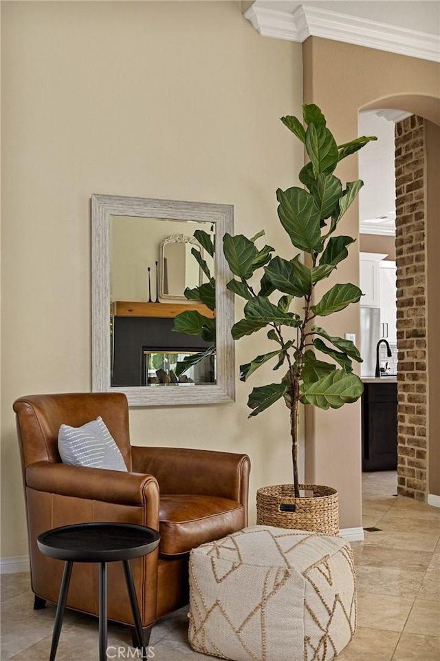 sitting room featuring sink, crown molding, and light tile patterned flooring