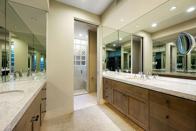 bathroom with a shower with shower door and vanity