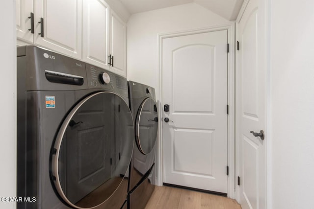 clothes washing area with cabinets, independent washer and dryer, and light hardwood / wood-style flooring