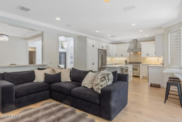 living room with light hardwood / wood-style flooring and ornamental molding