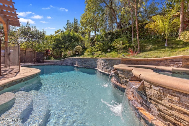 view of swimming pool featuring pool water feature and a hot tub