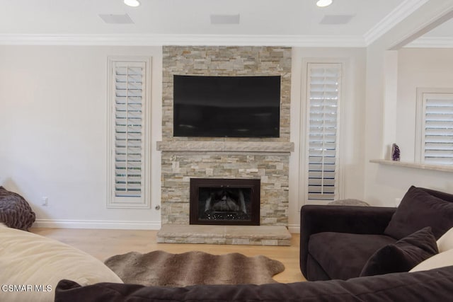 living room with light wood-type flooring, a fireplace, and ornamental molding