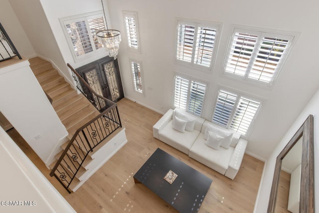 foyer entrance with wood-type flooring, plenty of natural light, and a chandelier